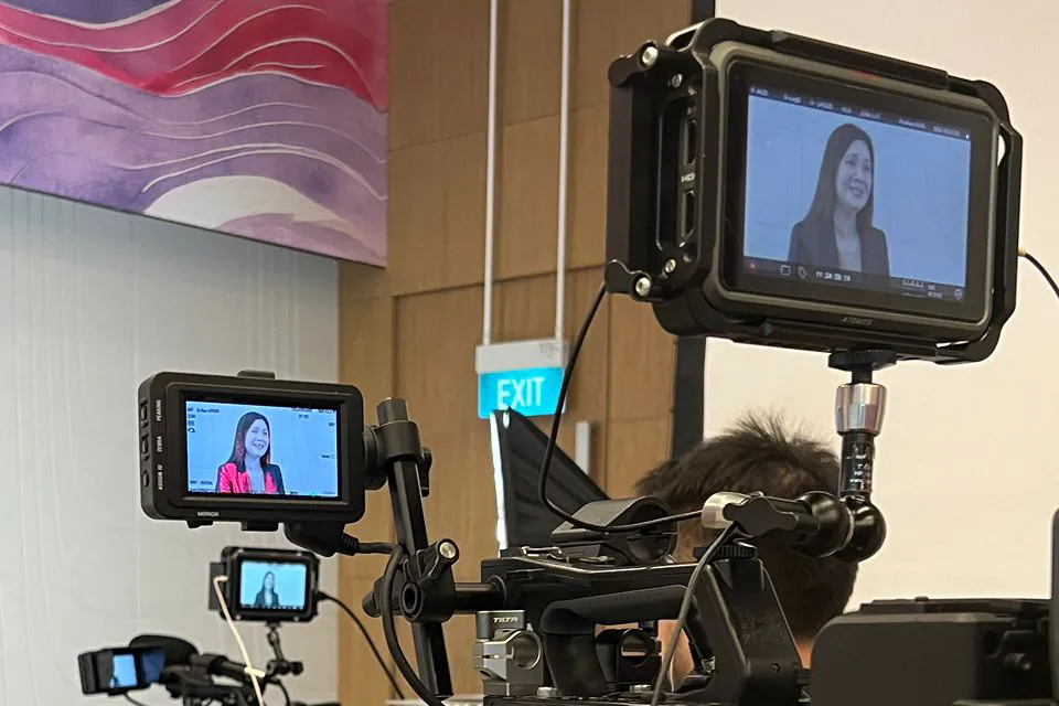 Camera and monitor framing a presenter during an office shoot