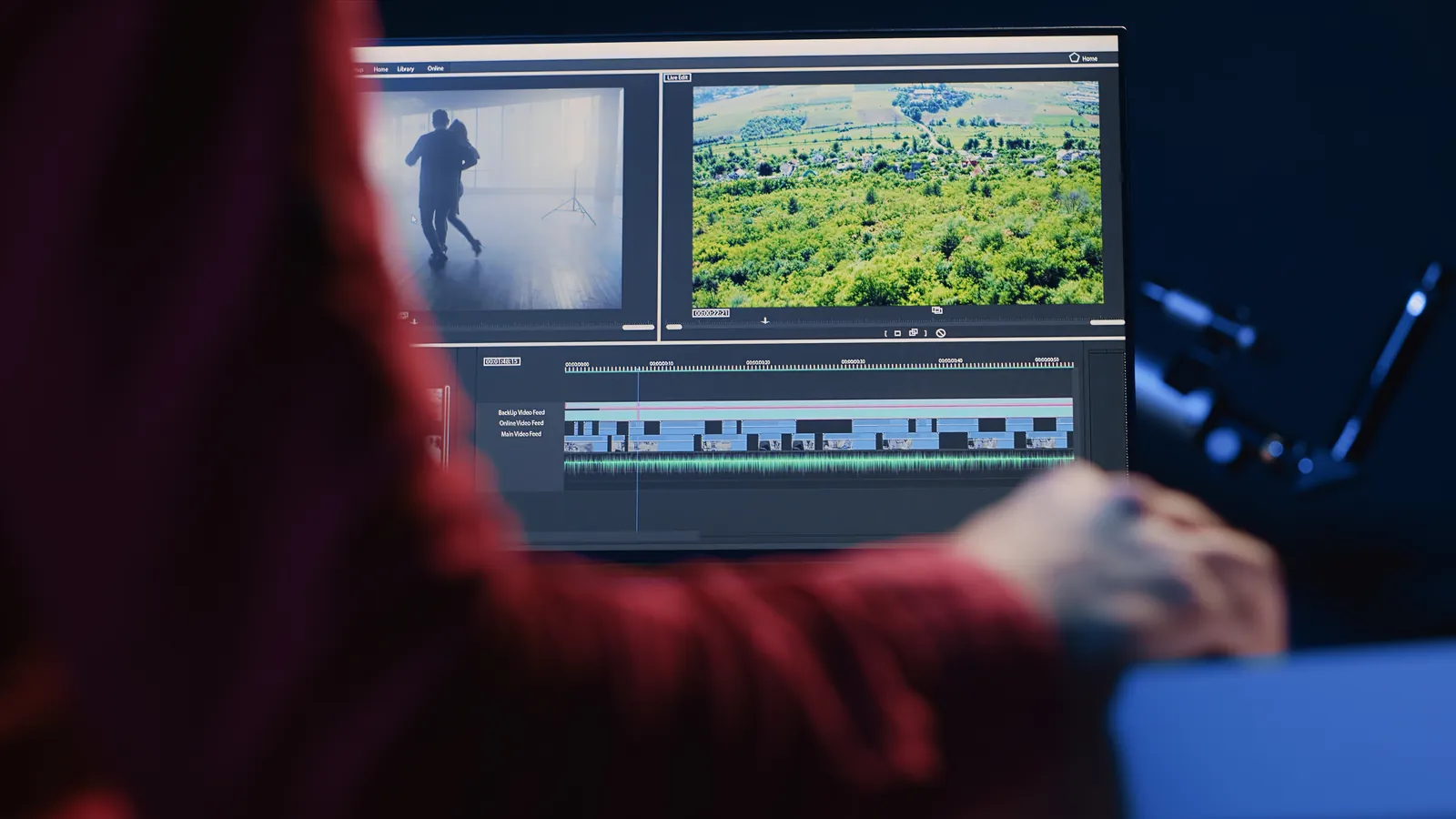 Editor reviewing a film montage on an editing timeline in a dark studio